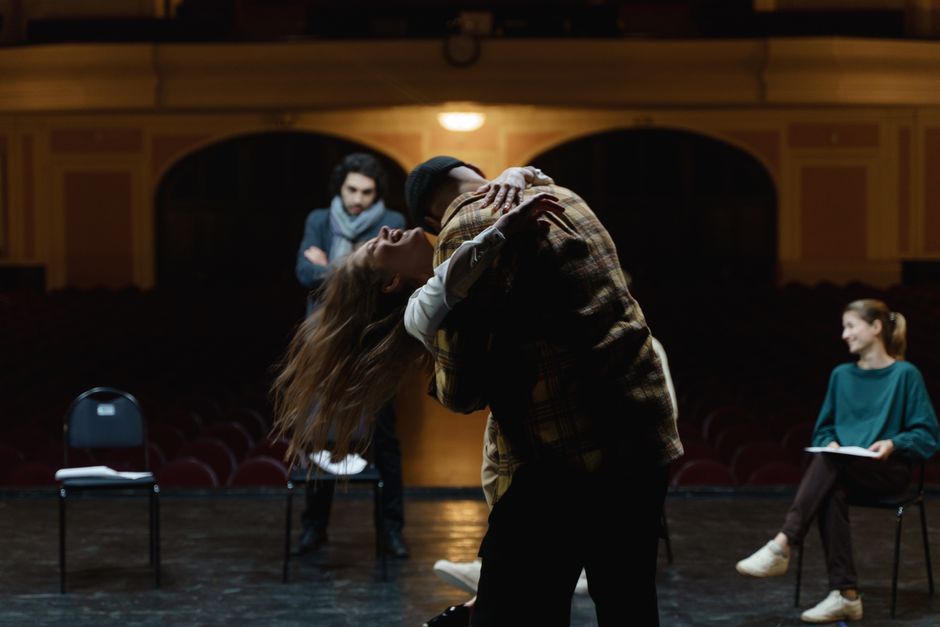 Actors in a dramatic rehearsal on a theater stage