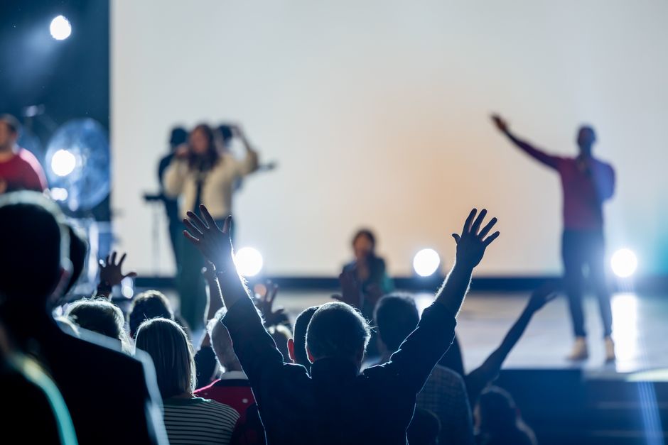 Crowd with raised hands enjoying a live indoor concert